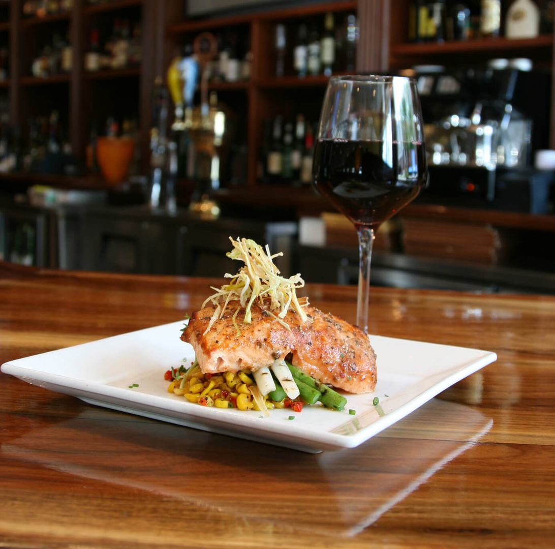 A plate of food and glass on the table