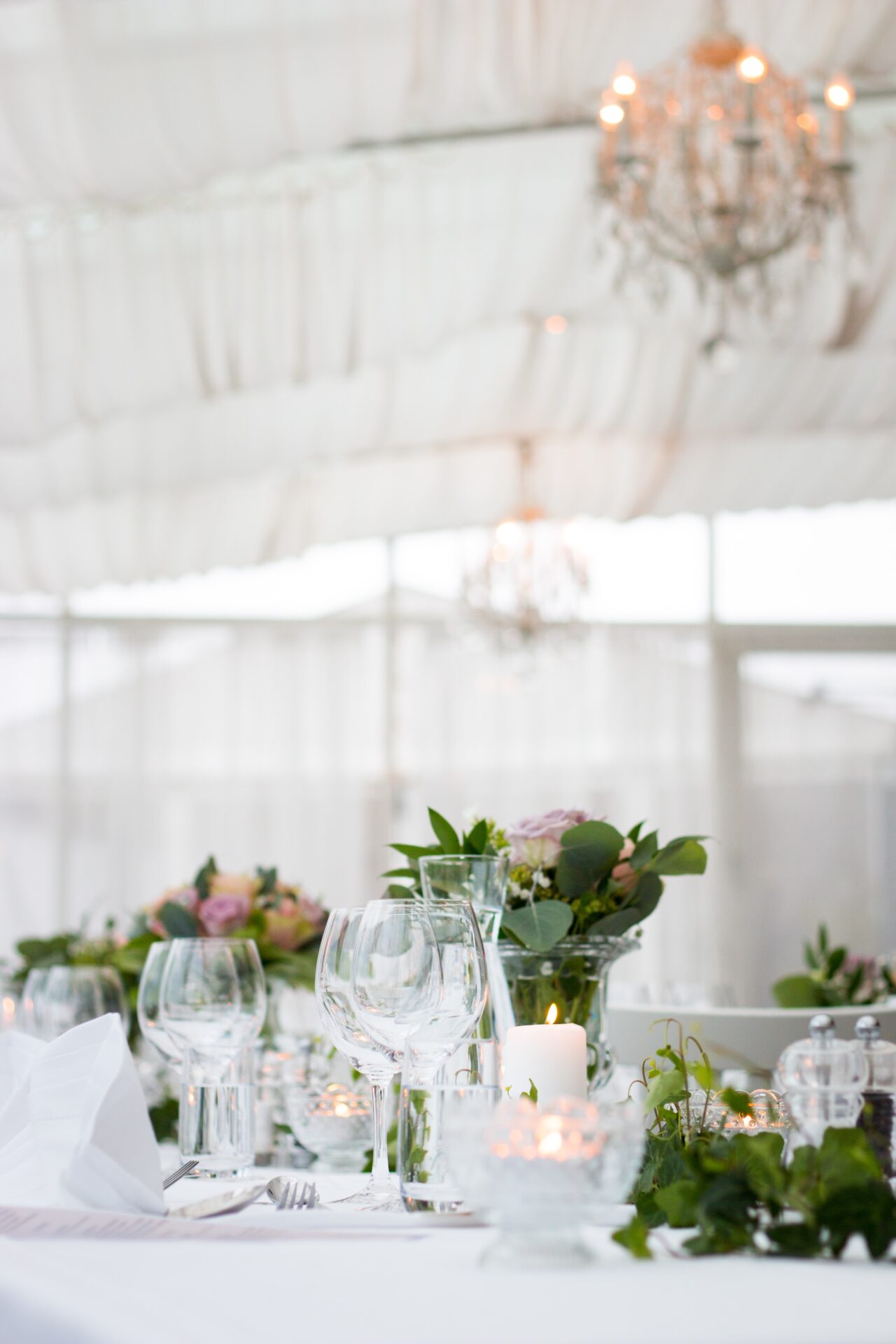 A table set up with wine glasses and candles.